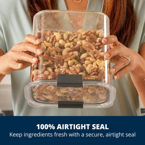 Woman holding Straight Up 12 Cup Airtight Food Storage Container with nuts inside, showcasing secure snap lid and clear design.