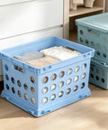 Top Rated Hassle Free Breezy Blue Stackable Plastic Storage Bin With Full Grip Handles For Quick Closet Pantry Garage Laundry Room Organization And Easy Everyday Hauling filled with folded clothes near a dresser.