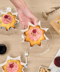 Hand holding cupcake in Bulk 4000 Pack Greaseproof Cupcake Liners 10.2 Ounce Disposable Oven and Freezer Safe Paper Muffin Cups