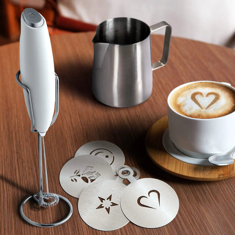 Complete Home Coffee Frother Set With Upgraded Ultra Stand Barista Grade Handheld Milk Foam Maker Mini Blender Whisk Frothing Pitcher Stencils And More Perfect Gift For Lattes Cappuccinos Mochas And Matcha At Home on wooden table with stainless pitcher, foam art stencils.