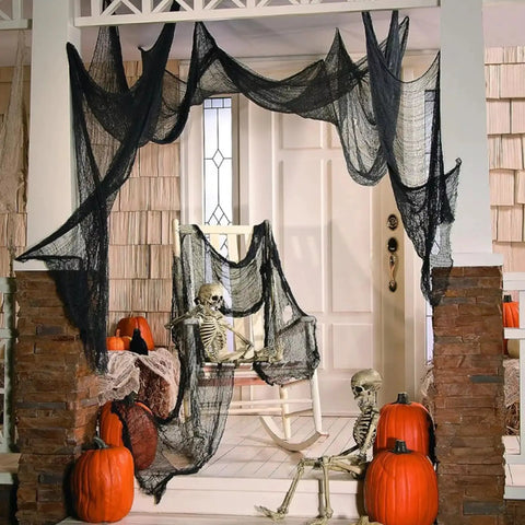 Six Pack Matte Black Cotton Crepe Sheets draped on porch with skeletons and pumpkins for Halloween decor.
