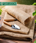 Natural Burlap Garden Fabric 40 Inch By 15 Foot Workhorse Jute Burlap For Weed Barrier Frost Protection Sun Shield And Diy Home Decor Crafts Perfect For Gardening Landscaping Arts And Crafts Projects displayed on a table with gardening tools