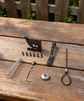 Heavy Duty Reliable Solid Carbon Steel Automatic Gravity Gate Latch With Self Locking Spring Catch For Driveway Man Gate kit parts on wooden table.