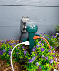Rock Solid Outdoor Power Stake Timer With Six Grounded Outlets And Photocell Auto Switch For Yard Decor in garden with purple flowers.