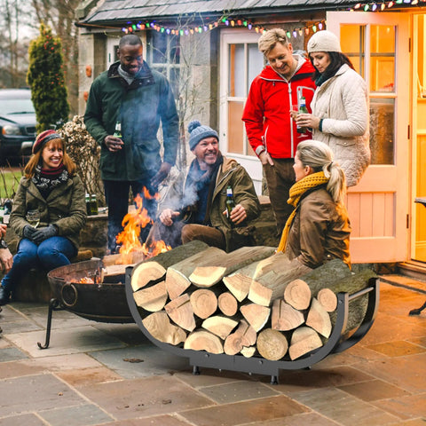 Beefy Firewood Rack For Outdoor Use, 29 Inch Log Holder, Black Steel Frame, near outdoor fire pit with people gathered.