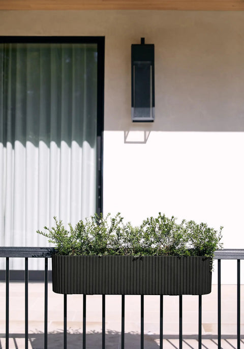 Badass Weatherproof Railing Planter Box With Secure Mounting Bracket, 36x8.5 inches, mounted with greenery on a balcony.