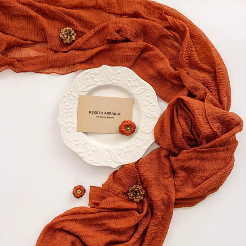 Rustic Fall Thanksgiving Table Runner Terracotta Cheesecloth Weave 120 Inches Long Hand Dyed Soft Cotton Gauze with a plate and decorations.