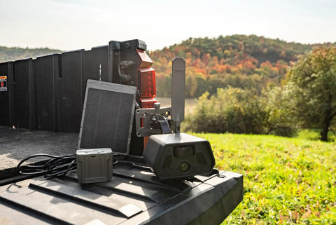 Run Forever Solar Panel With Built In High Capacity Battery For Trail Cameras on truck bed with charging equipment and landscape.