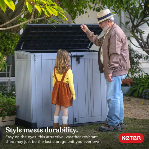 Store It Out Prime Outdoor Resin Storage Shed With Hydraulic Pistons shown in a backyard setting with a man and child.