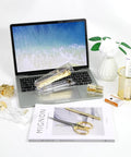 Shiny Gold Tone Office Desk Accessories Set With Acrylic Stapler Tape Dispenser Ballpoint Pen on desk with laptop