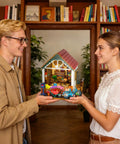 Two people holding Totally Awesome Miniature Dollhouse Kit With 3D Wooden Tiny Building Model Puzzle And LED Lights For Beginners