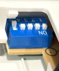 Close-up of dip switches on UC7848T V2 Fan Remote Transmitter Replacement With Wall Holder For Ceiling Fans, 5 Dip Switches, Includes Wall Mount, 9V Battery Not Included, Easy Install, Fits UC7848T V2 and Discontinued Versions.