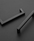 Black 5 Inch Square Cabinet Pulls 30 Pack Stainless Steel Kitchen Cabinet Handles Modern Hardware lying on a black surface