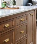 Heavy Duty 10 Pack Of Three Inch Antique Brass Cabinet Pulls With Slick Zinc Alloy Build and Tight Screw Placement For Kitchen Drawers, showcased on wooden kitchen drawers.