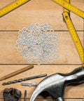 100-Pack M8 Stainless Steel Spring Lock Washers With Badass Split Design to Prevent Loosening, arranged on a wooden workbench.
