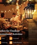 Two Pack Motion Sensor Outdoor Wall Lights Dusk To Dawn Waterproof Exterior Lanterns For Porch Garage Doorway And Backyard Black Finish With Wide 220 Degree Detection And Up To 40 Feet Range illuminating a backyard dinner setting.