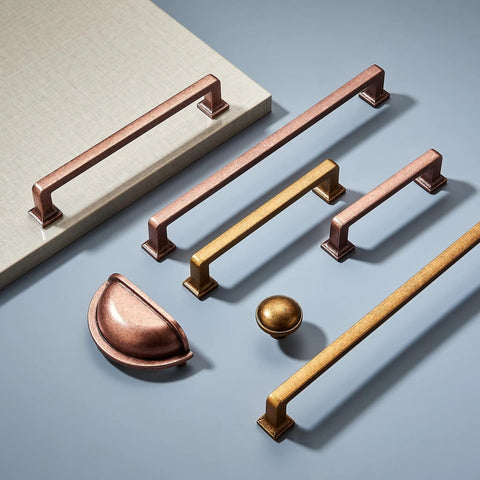 Two Pack Rock Solid Zinc Alloy Cabinet Cup Pulls With 12 Inch Hole Center Featuring Knockout Aged Copper Finish Vintage Drawer Handles For Kitchen Cabinetry And Vanity Total Upgrade displayed on a grey surface.