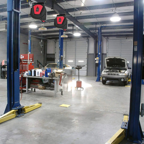 Heavy Duty Built Tough 50 Foot Retractable Extension Cord Reel With Three Grounded Outlets in a garage workshop setting