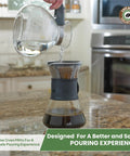 Stove Top Borosilicate Glass Whistling Tea Kettle 12 Cup 48oz BPA Free German Made See Through Boil For Gas Electric And Glass Ranges Durable Kitchen Kettle For Fast Flavorful Tea being poured into coffee maker on kitchen countertop.
