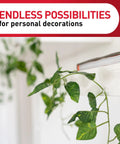Damage Free Indoor Mini Light Clips Value Pack With 45 Clips And 54 Strips in use holding a green vine on a white wall.