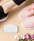 White Self Adhesive Sneaker Repair Patches For Fresh Kicks Instant Heel Hole Fix beside pink and black sneakers on a light surface.