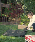 Woman setting up Pro Grade 5oz Landscape Fabric Weed Barrier Mat 3 Feet By 50 Feet Heavy Duty Ground Cover in garden