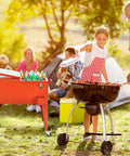 Outdoor party scene with 80 Quart Rolling Cooler Ice Chest With Wheels And Bottle Opener in red next to a barbecue.