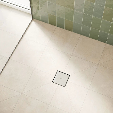 Square Tileable Shower Drain Set With Brushed Stainless Steel Construction And Flush Floor Mount Design For Modern Bathrooms on a tiled shower floor.