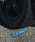 Heavy Duty Oil Drain Screw Removal Tool And 30mm Hexagonal Socket Wrench For Cars near a tire on asphalt surface.