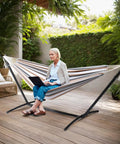 Heavy Duty Hammock Stand 450 Lbs Capacity, Adjustable Steel Frame For Indoor Outdoor Use with person sitting on deck