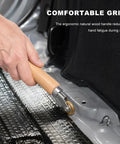 Close-up of Top Shelf 2 In 1 Seam Roller Kit with ergonomic wood handle, sealing vinyl tarp with brass wheel on roofing surface.