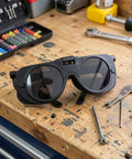 Heavy Duty Black Welding Safety Glasses With Dual Layer Lens To Block Bright Arc Light And Keep Eyes Comfortable For All Day Shop Grind Built Like Iron For Tough Fabrication Jobs And Solid Impact Protection on a workbench.