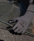 Smart Touch Work Gloves With Nitrile Grip Palm holding glass, seamless knit nylon, size large, tough for warehouse handling