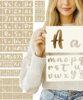 Woman holding Go To Calligraphy Stencil Kit With 50 Pieces Large 4 Inch And Small 2 Inch Alphabet Stencils Numbers And Floral Designs