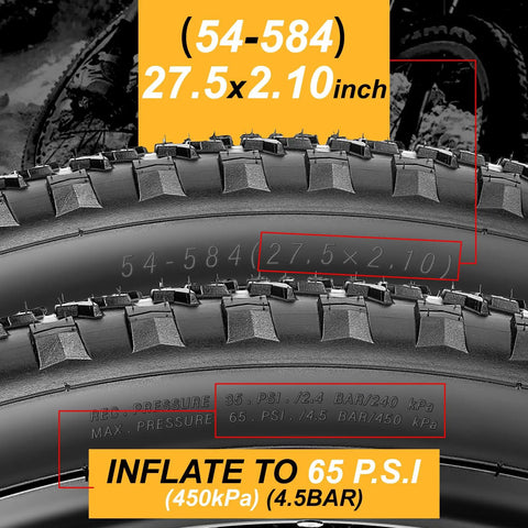 Close-up of 27.5x2.1 inch mountain bike tires with tread and labeling, inflate to 65 PSI, size markings visible.