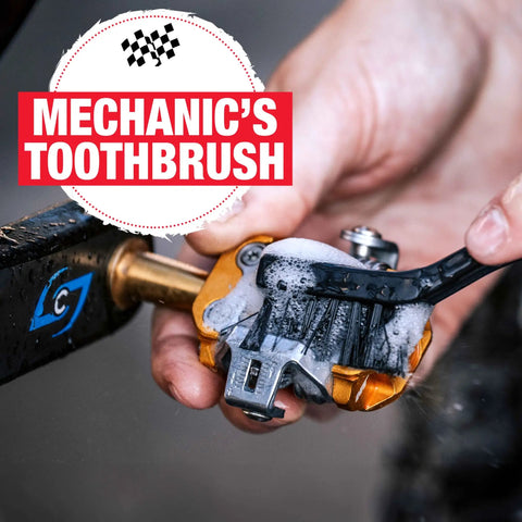 Using a brush from the Five-Piece Mechanic-Style Bicycle Cleaning Brush Set For Quick Pro-Grade Cleaning on a bike component.