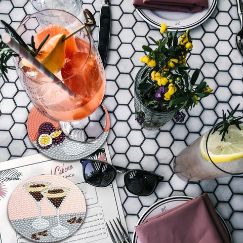 Hexagonal table with Dope 6 Piece Diamond Painting Coaster Set With Holder For Drinks And Coffee Tables, flowers, and glasses of cocktails.