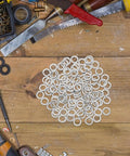 Kick Butt Quality 100 Pack M8 Stainless Steel Split Ring Spring Lock Washers on a wooden table among tools.