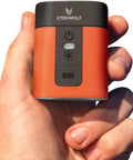 Hand holding Tiny But Mighty Portable Air Pump For Inflatables With 2600mAh Battery And Camping Light, orange compact size