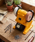 Top Shelf Mini Bench Grinder With 18V Compatible Battery For Precision Sharpening And Metal Polishing Portable Workstand on wooden table.