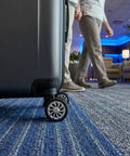 4 Piece Suitcase Wheels Replacement Kit Featuring Universal 360 Degree Swivel Casters For No Fuss Installation Smooth Glide Travel Bag And Premium Rolling Trolley Case Parts on a suitcase in a hotel lobby.
