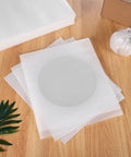 Stack of 100 Pcs EPE Foam Cushion Pouches on wooden table, ideal for shipping fragile items and dish protection.
