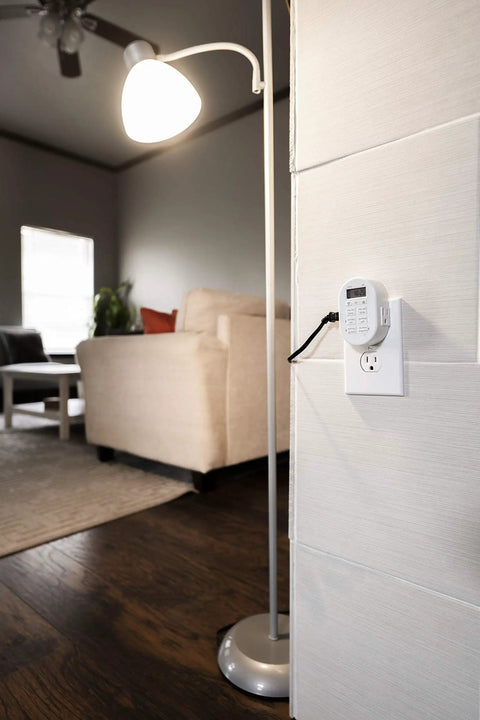 Smooth Operator Indoor Plug In Digital Timer With Two Grounded Outlets And Sunsmart Sunrise Sunset Tracking For Zero Hassle Weekly Scheduling Slick White Build mounted on wall next to lamp in living room.