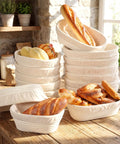 30 Set Bulk Oval Banneton Bread Proofing Baskets With Cloth Liners Natural Rattan Dough Bowls Kit For Sourdough Baking At Home 8.3 Inch And 9.8 Inch Sizes Ideal For Home Bakers stacked on a kitchen counter with fresh bread.