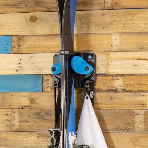 Kickin Sweet Indoor Ski And Snowboard Wall Mount With Rock Solid Damage Free Grip For Garage Storage Holds Boards Poles Safe In Space Saving Premium Gear Rack Cyan Single Pack showing skis in mount on wood wall.