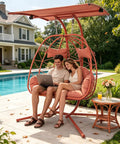 Double Egg Chair With Stand And Adjustable Canopy for Indoor Outdoor Use with orange red cushions by poolside