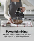 Slick Electric Hand Mixer Packing Six Speeds Plus A Dedicated Stir Button To Dodge Splatter While Whipping Up Thick Dough Or Fluffy Batter Plus Dual Beaters And Heavy Duty Hook Attachments in use mixing chocolate batter.