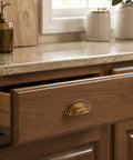 Three Pack Antique Brass Half Moon Cup Pulls For Kitchen Cabinets And Drawers Featuring Hella Smooth Finishes And Rock Solid Zinc Alloy Build With Detailed Cuts That Bring Fresh Charm To Furniture And Vanity Projects Quick And Easy on a wooden drawer.