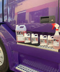 Touchless One Step Car Wash Detergent Soap Concentrate With Degreasing Power bottles and spray on a truck step
