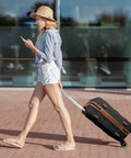 Woman walking with a black suitcase featuring replacement luggage wheels for specific suitcase model black color not compatible with other brands easy quick installation no tools required durable rolling wheels for smooth quiet travel.